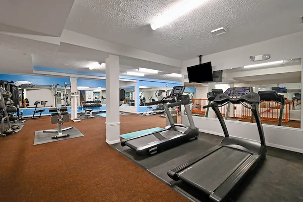 Woodspring Apartments fitness center with treadmills and strength training equipment