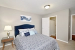 Bedroom with large bed and closet at Woodspring Apartments