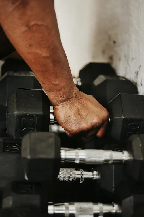 Man lifting dumbbells from a rack