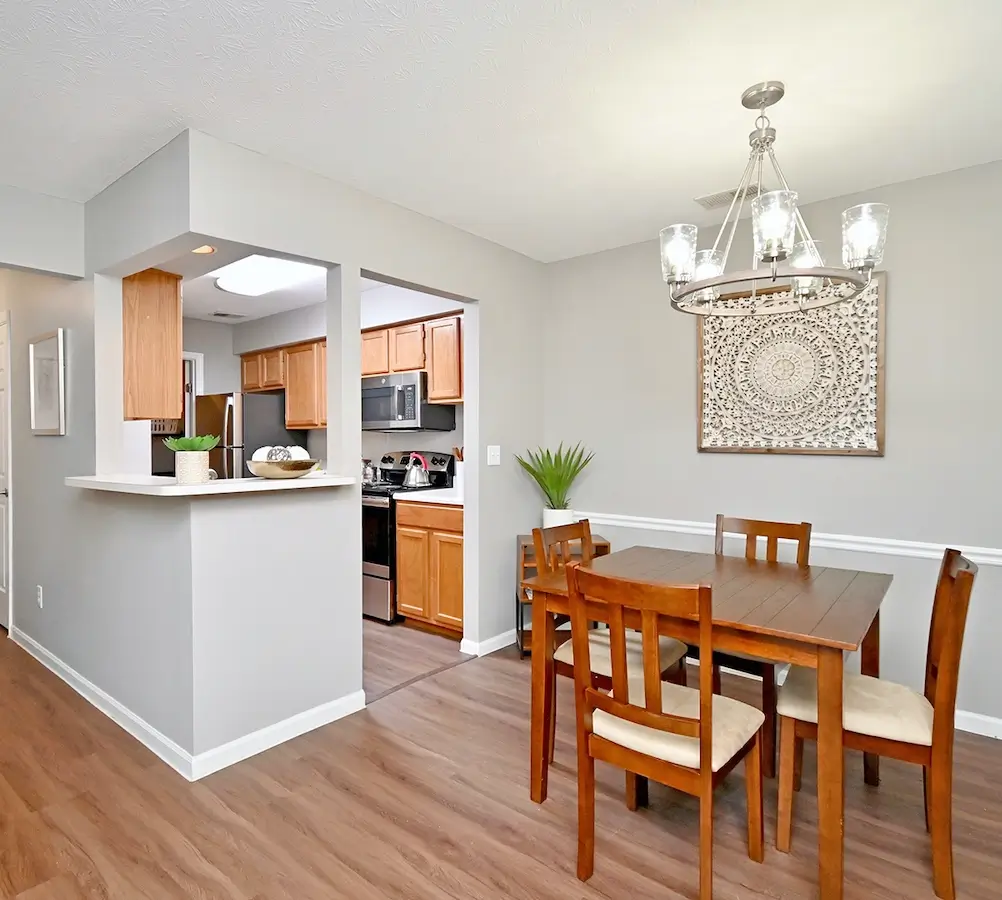 Kitchen and dining room in Woodspring Apartments with wood-style plank fooring