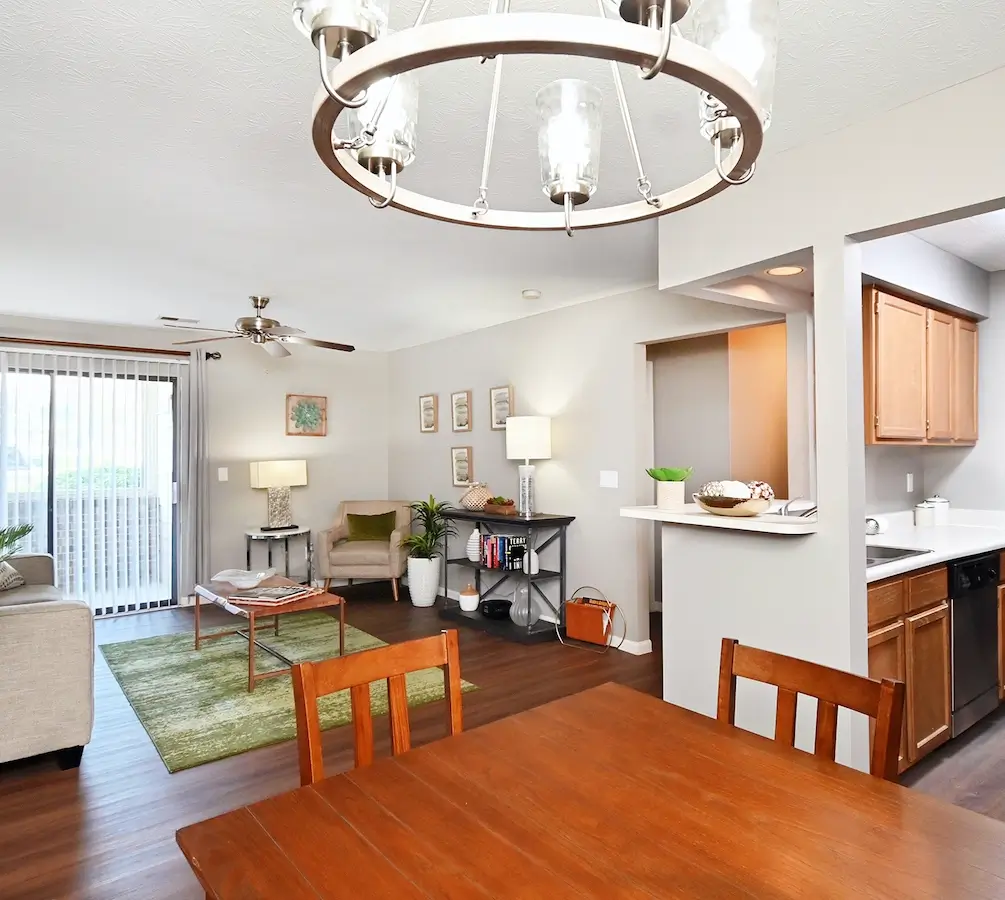 Living room and kitchen with wood-style plank flooring and ceiling fan